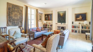 A living room with a sofa, armchairs, a coffee table, a bookshelf, and a fireplace. - Spacious Andalusian Country House with Pool Near Cabo de Gata (Níjar)
