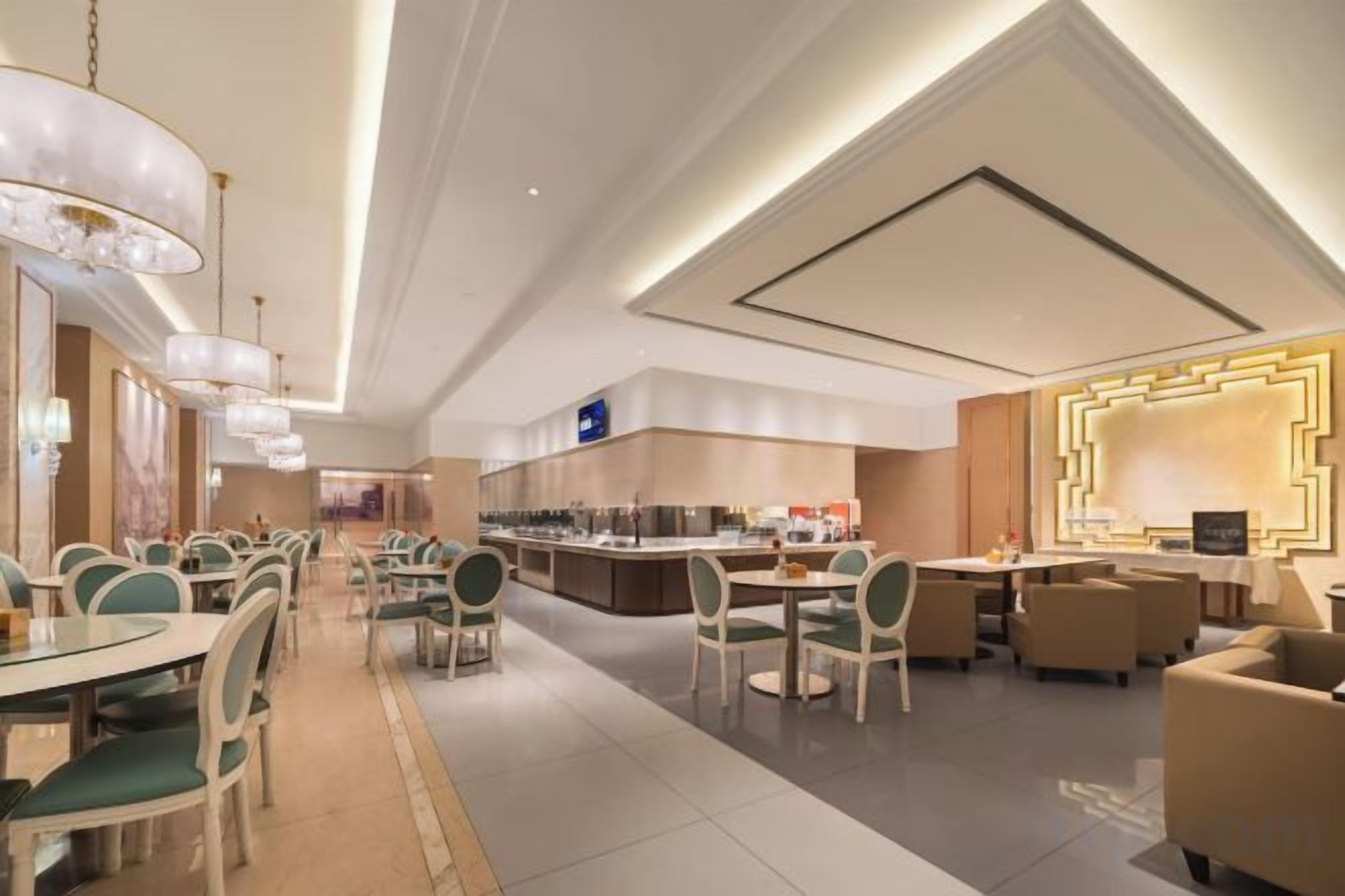 Un moderno vestíbulo de hotel con barra central, mesas de comedor y asientos cómodos.