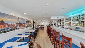 A bar area with a neon sign reading "Chesapeake Bay" and a mural of a cityscape on the wall. - XPLORIE ACTIVITIES & LINENS INCLUDED*!  PLAZA - 2BR/2BA with Open Den. Indoor & Outdoor Pools, Tiki Bar. (Ocean City)