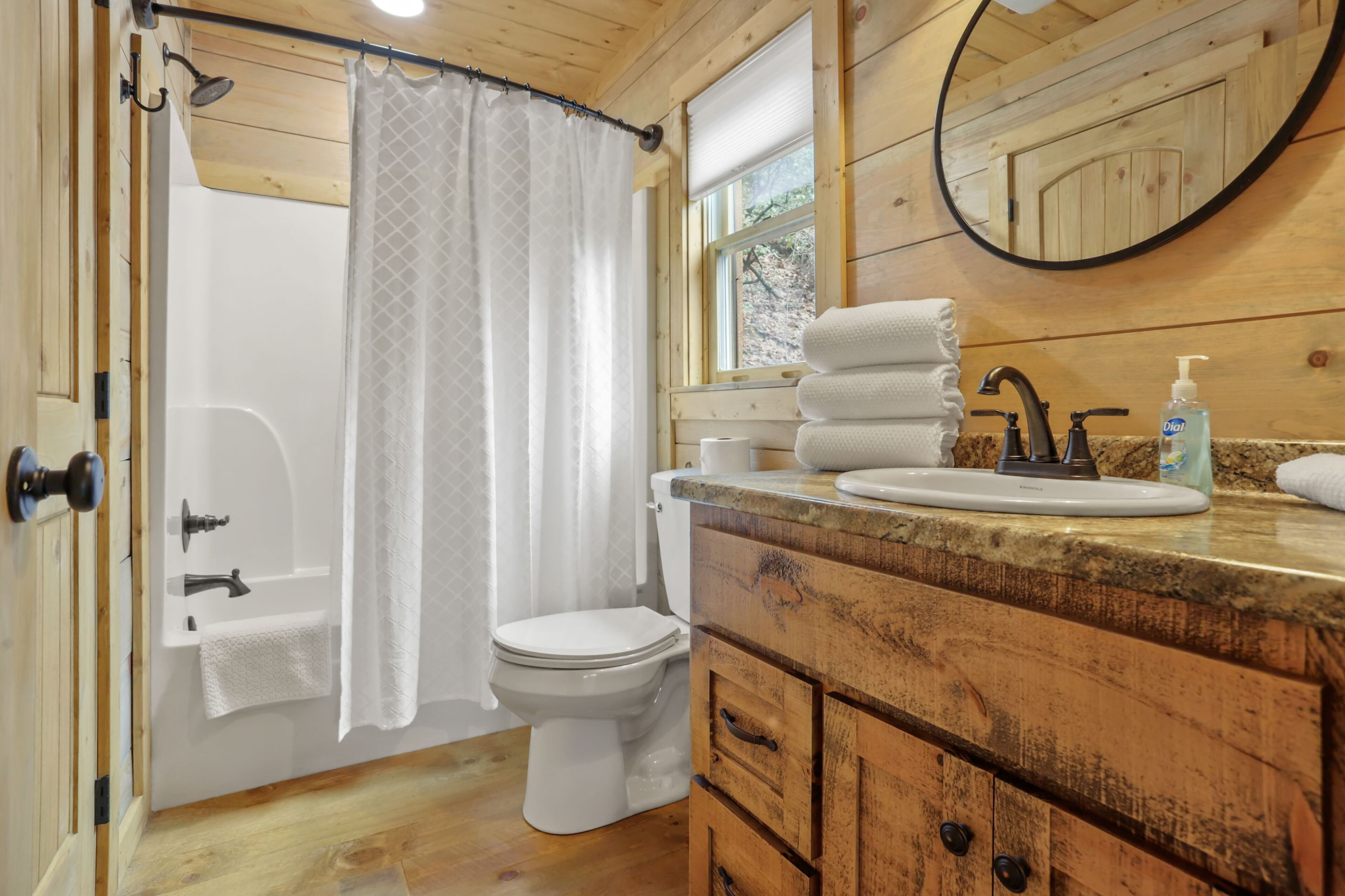 Een bad/douchecombinatie, een haardroger, handdoeken, zeep