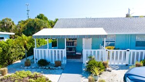 A house with a covered porch, a small garden, and a pathway leading to the entrance.