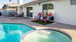 Ein Poolbereich mit Whirlpool, Sitzgelegenheiten im Freien und einer überdachten Terrasse.