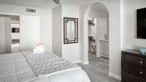 Ein Schlafzimmer mit einem Bett, einem Schminktisch und einem Spiegel.