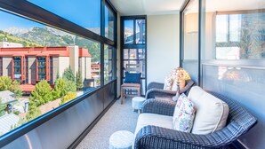 A balcony with wicker furniture, a chair, and a small table. - Amazing condo next to the American Eagle lift.  Free WiFi, Free Parking (copper mountain)