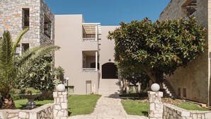 A stone pathway leading to a building with a balcony and a staircase. - Erato Beach Hotel Adults Only (Platanias)