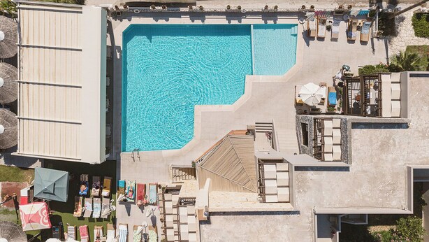 A rooftop swimming pool with lounge chairs and umbrellas. - Erato Beach Hotel Adults Only (Platanias)
