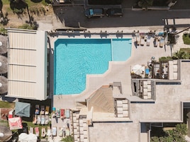 A rooftop swimming pool with lounge chairs and umbrellas.