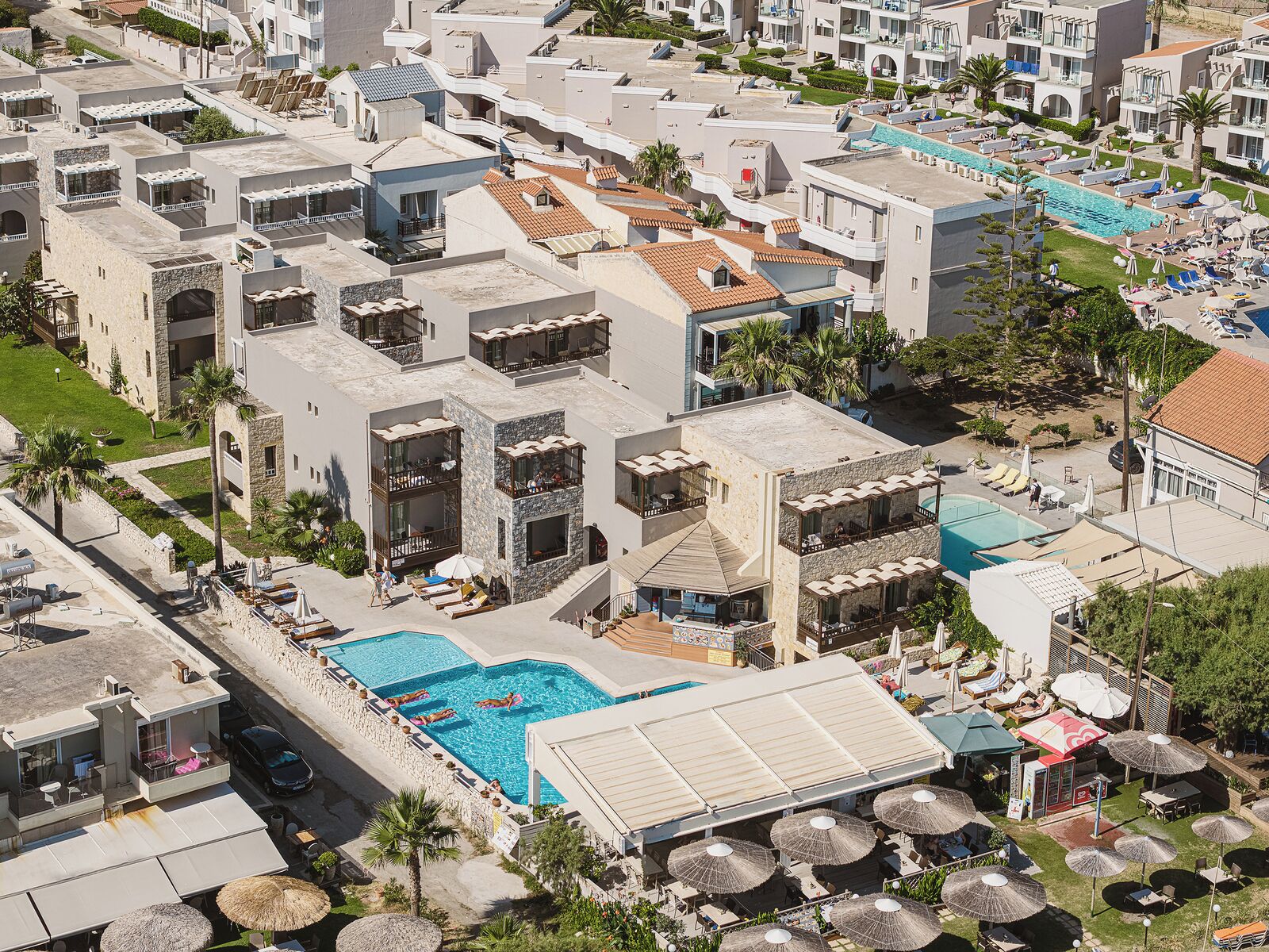 Un complejo turístico con varias edificaciones, una piscina y zonas de estar al aire libre.
