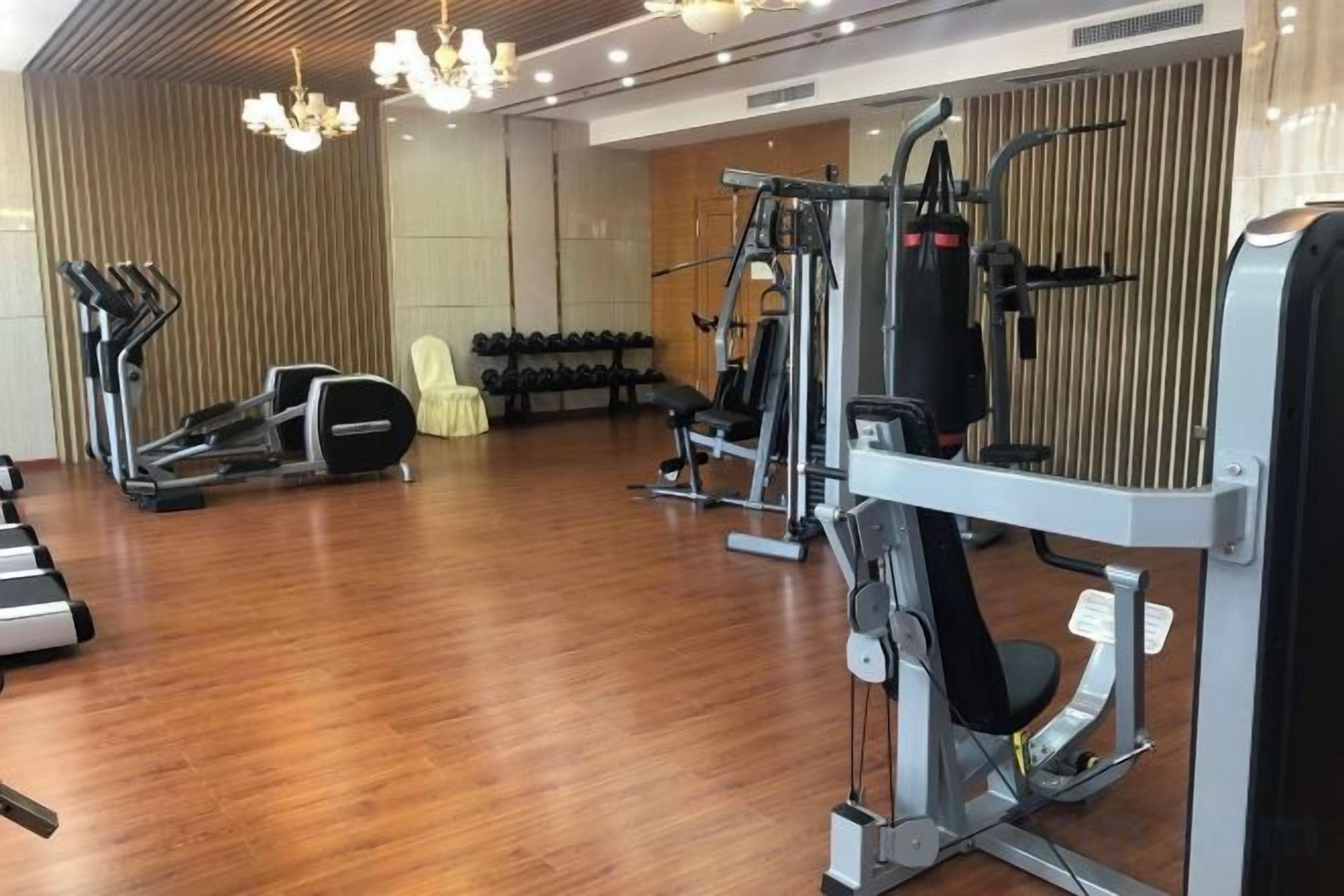 Un gimnasio con cintas de correr, mancuernas y máquinas de pesas.