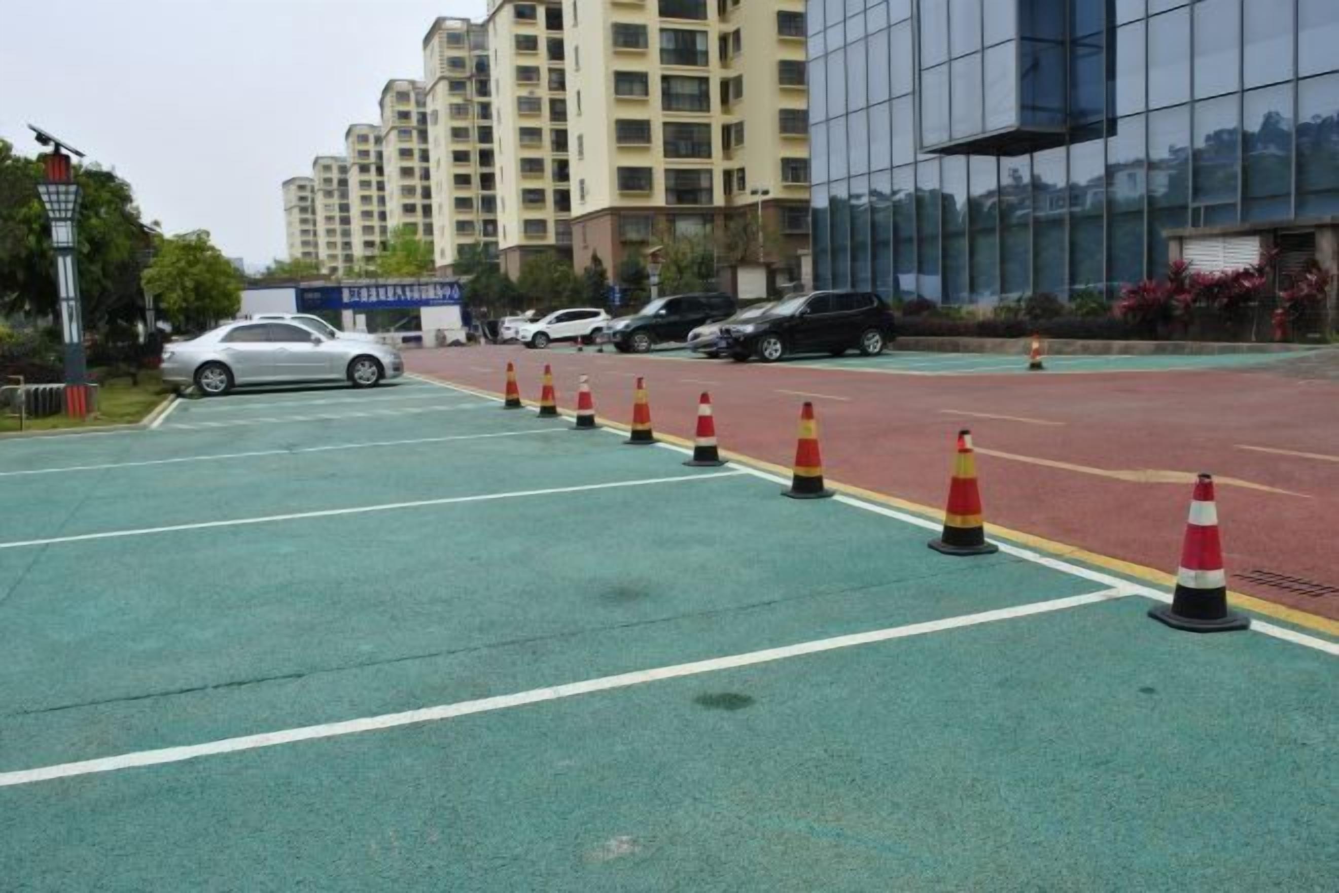 A parking lot with marked lanes and traffic cones.