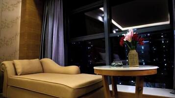 Una habitación con un sofá, una mesa redonda y un florero con flores.