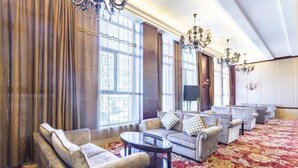 A spacious lobby with a red floral carpet, multiple sofas, and a chandelier. - Jinxin Hotel (Xiangyuan)