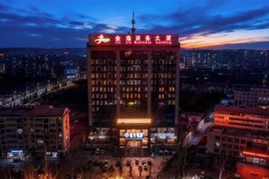 A multi-story building with illuminated signage, a prominent entrance, and a surrounding urban environment. - Jinxin Hotel (Xiangyuan)