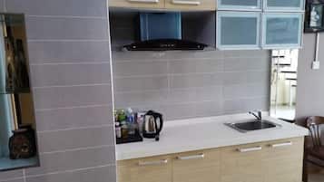 A modern kitchen with grey tiles, a built-in stove, and a sink.