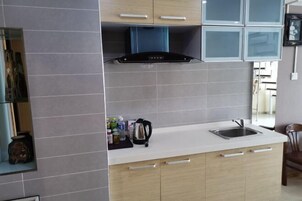 A modern kitchen with grey tiles, a built-in stove, and a sink.