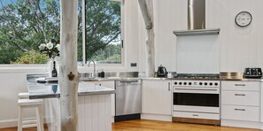 A modern kitchen with white cabinetry, a stainless steel stove, and a dishwasher.