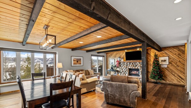 A spacious living room with a wooden ceiling, a fireplace, and a Christmas tree. - Winterset 3 3 Bedroom Condo by RedAwning (Steamboat Springs)
