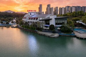 A hotel with a waterfront view, a swimming pool, and a restaurant sign. - Huatian Hotel (Jiahe)