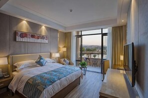 Una habitación de hotel moderna con una cama grande, un escritorio, un televisor y un balcón con vista a la ciudad.