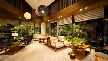 A modern living room with a sofa, armchairs, a coffee table, and a fireplace.