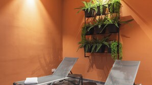A spa room with two reclining chairs, a wall-mounted plant shelf, and a tiled floor. - Holiday Inn - the niu, Amity Potsdam by IHG (Potsdam)