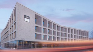 A modern building with a prominent sign reading "the niu". - Holiday Inn - the niu, Amity Potsdam by IHG (Potsdam)