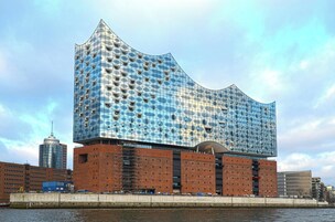 Ein modernes Gebäude mit einer markanten, wellenförmigen Fassade in Hafennähe.