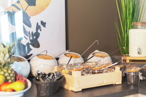 Un bufé de desayuno con diferentes alimentos y utensilios.
