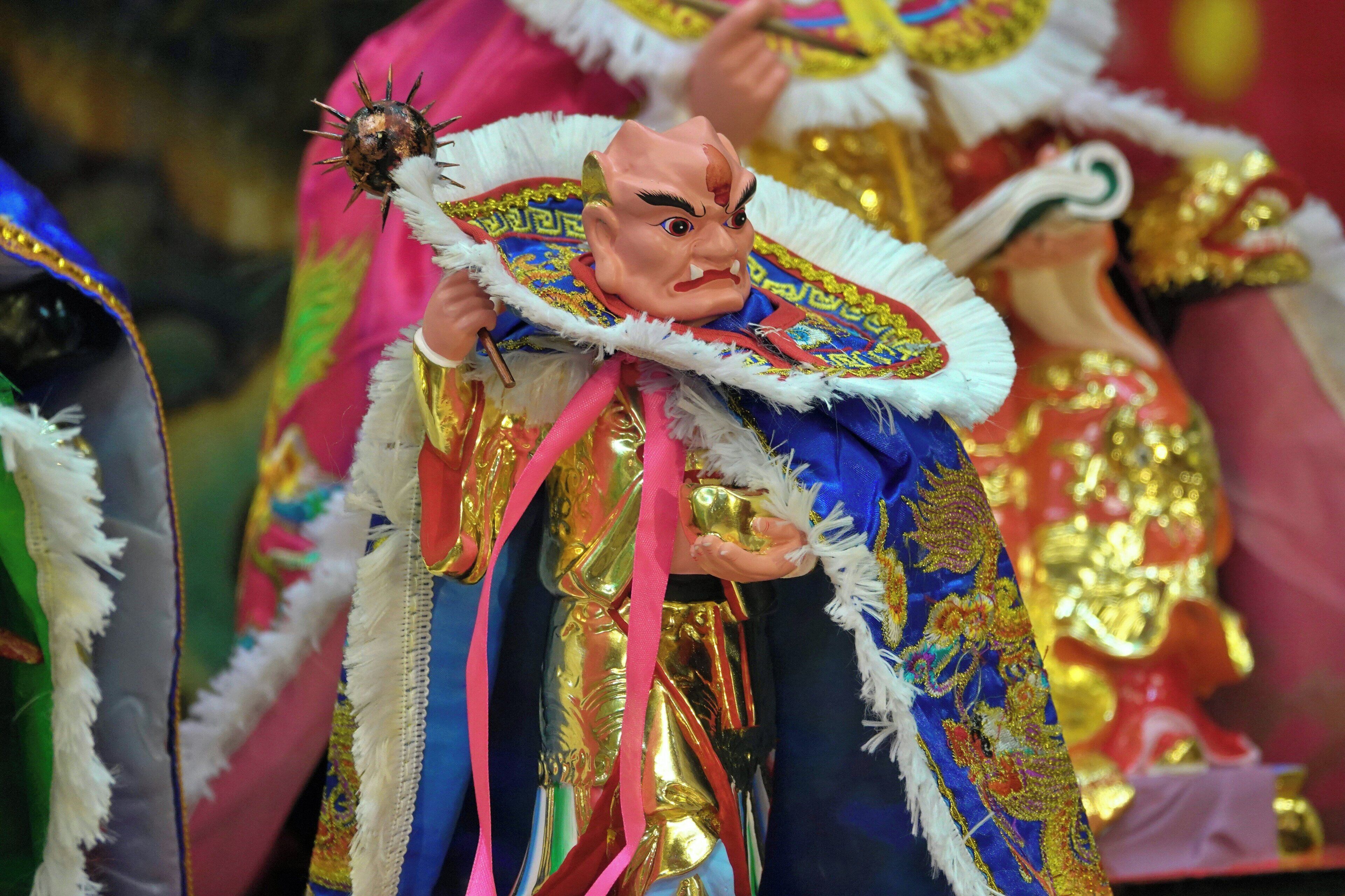 A person in traditional attire holding a ceremonial object.