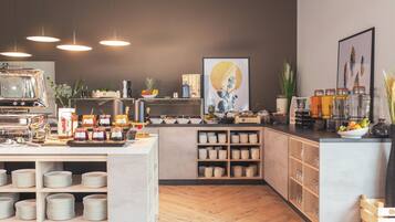 Una cocina moderna con una isla central, armarios de madera y diversos alimentos y utensilios de cocina.