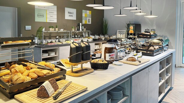 Un bufé con diferentes opciones de comida y una estación de café autoservicio.