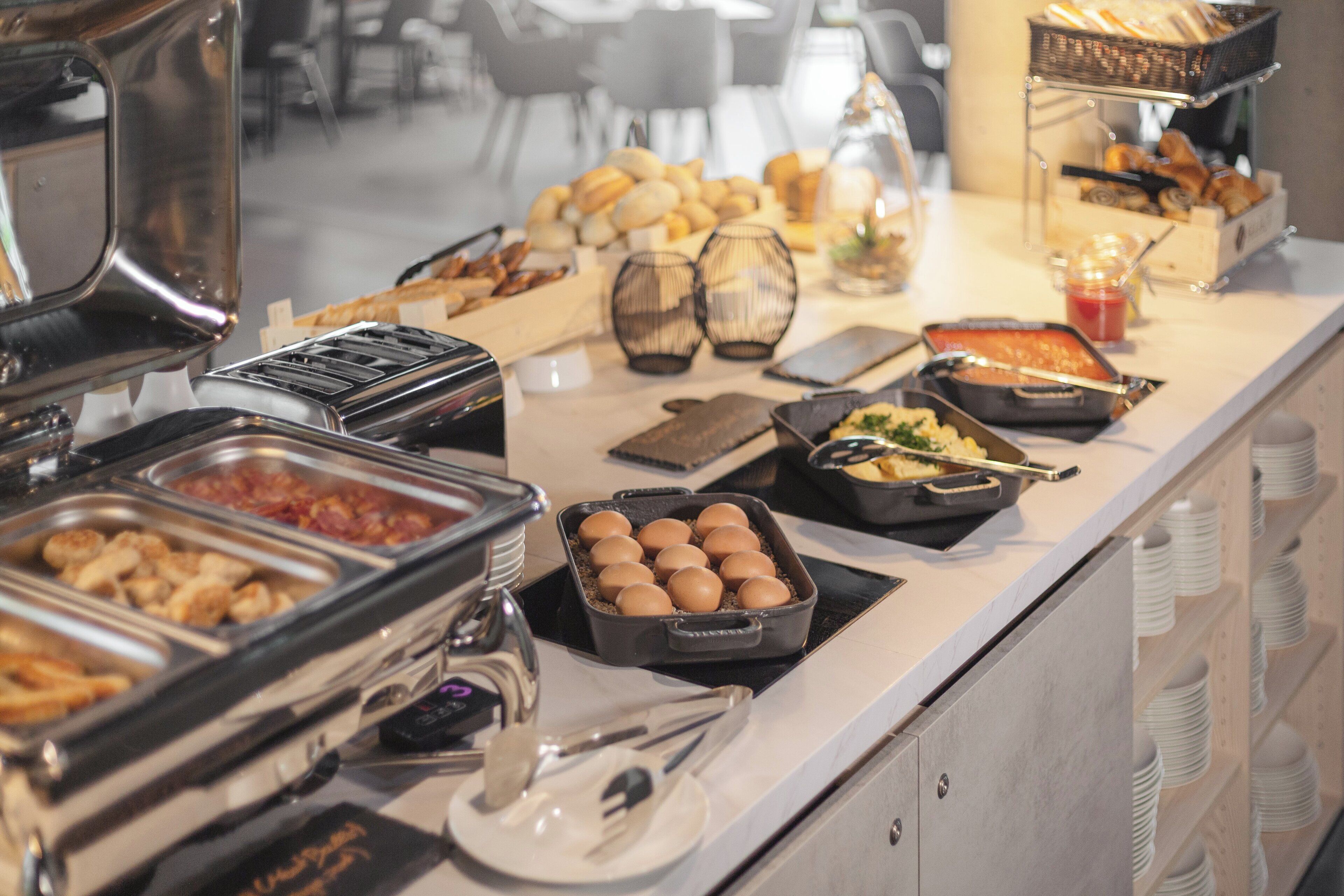 A buffet with various food items and utensils.