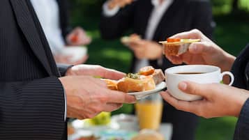 A group of people at a buffet with food and a coffee cup.