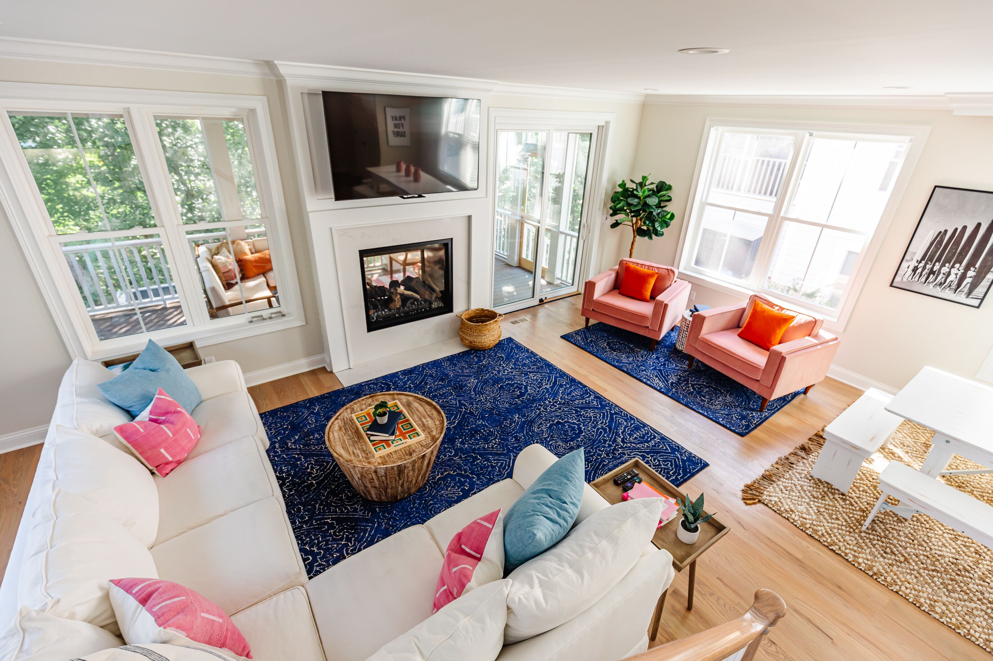 A spacious living room with a fireplace, large windows, and a cozy seating area.