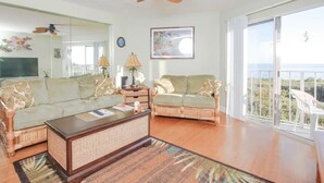 A spacious living room with a large sofa, a coffee table, and a balcony with a view. - Keys Deal w/Cafe & Pool Bar! Up to 20% Off Oceanfront 2/2 with Private Beach (Tavernier)