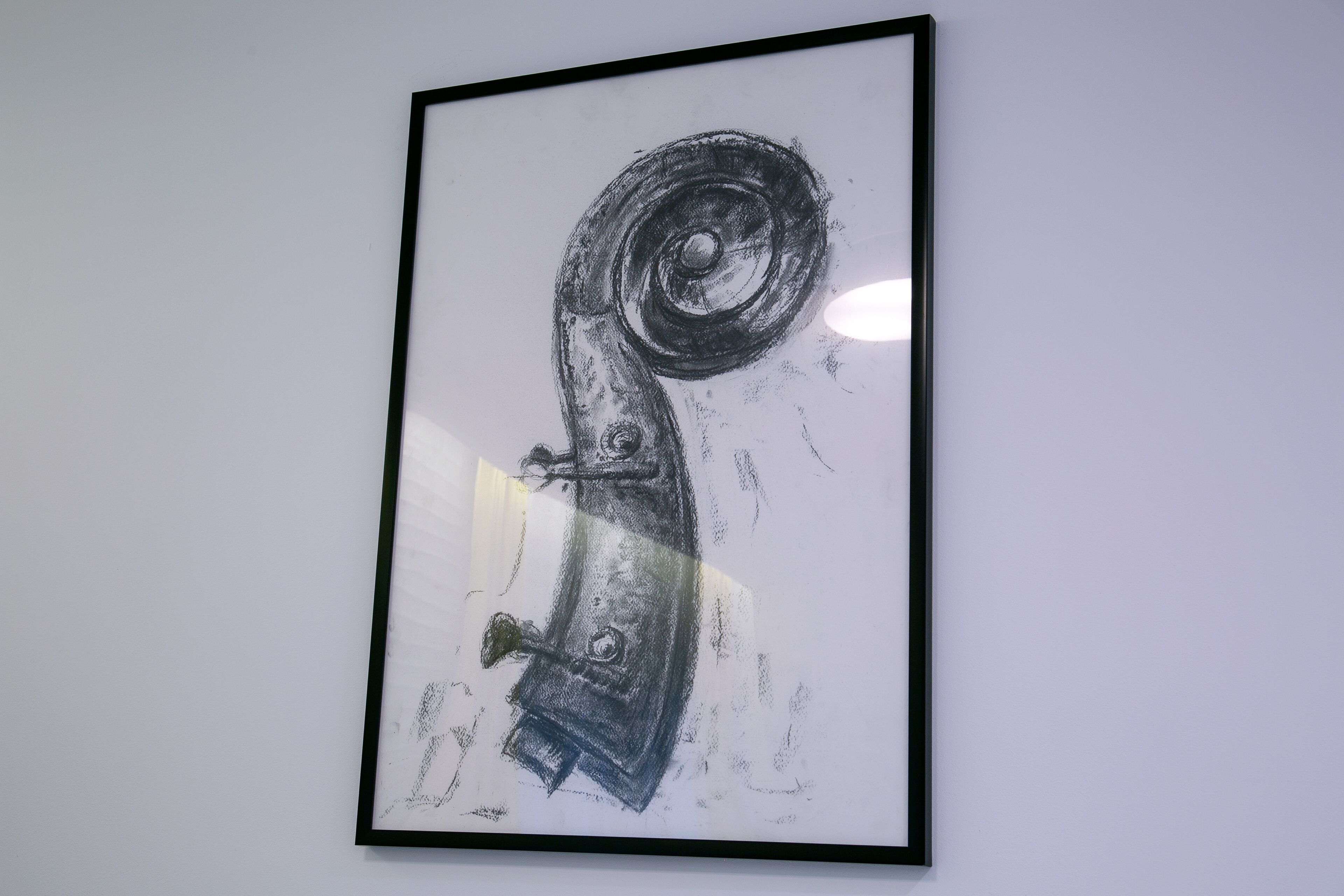 Ein gerahmtes, abstraktes Kunstwerk an einer schlichten Wand.