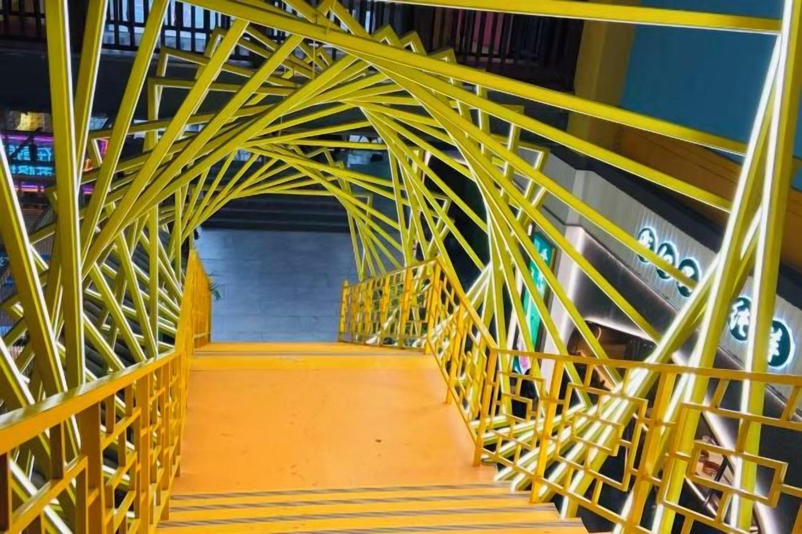 A yellow metal staircase with a handrail, leading to a higher level.