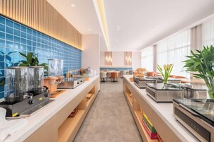 Una cocina moderna con electrodomésticos de acero inoxidable, un salpicadero de azulejos azules y una isla central con asientos.