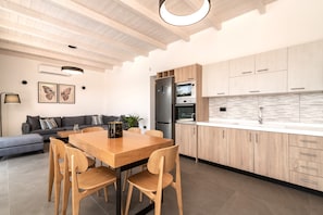 A modern kitchen with wooden cabinets, a built-in oven, and a large island with seating.