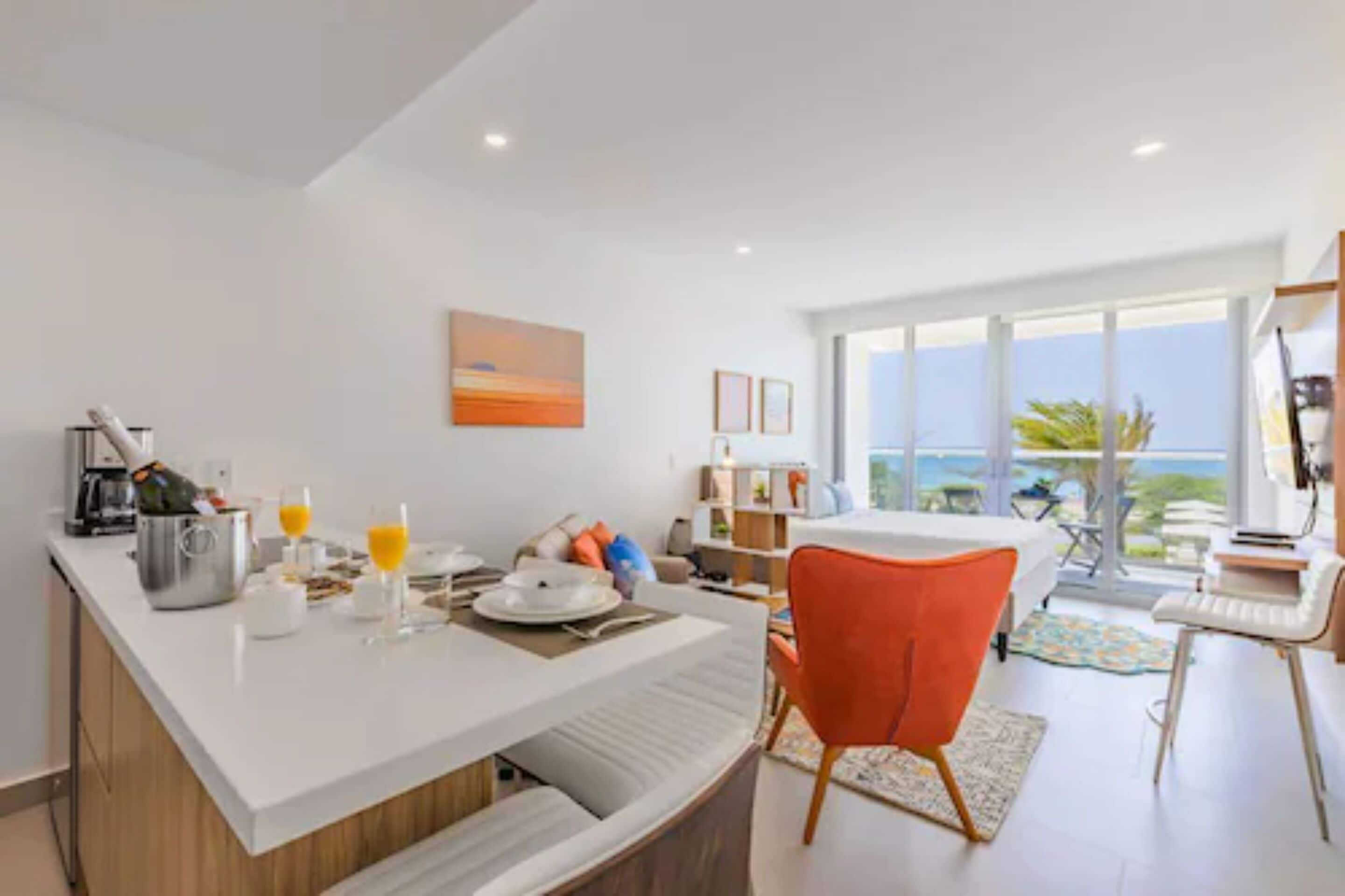 Una cocina moderna con espacio para desayunar, un comedor con vista al océano y una sala de estar luminosa y espaciosa.