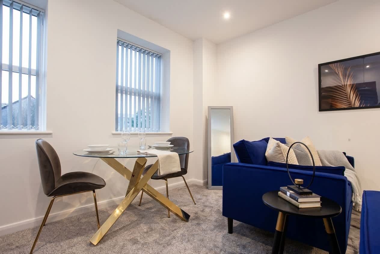 Un espacio moderno para vivir con una mesa de comedor, sillas, un sofá y una mesita auxiliar.
