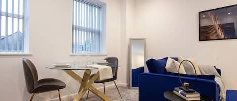 Un espacio moderno para vivir con una mesa de comedor, sillas, un sofá y una mesita auxiliar.