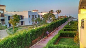 A pathway lined with greenery, leading to a building with multiple balconies. - Cecilia Hurghada (Hurghada)