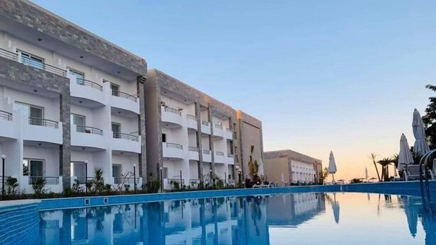 A modern hotel with a pool, multiple balconies, and a clear sky. - Cecilia Hurghada (Hurghada)