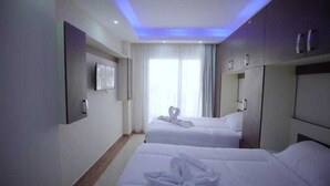 A hotel room with two beds, a flat-screen TV mounted on the wall, and a large window with curtains. - Cecilia Hurghada (Hurghada)
