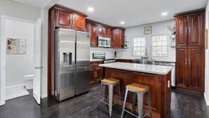 Una cocina moderna con armarios de madera oscura, electrodomésticos de acero inoxidable y encimera de granito.