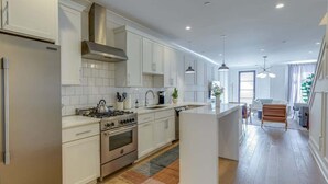 A modern kitchen with white cabinetry, stainless steel appliances, and a central island. - Belmont Music Row 4 Bed, Rooftop, 10 Minutes To DT | 24 Hour Hospitality Team, Perfect for Groups, 7.5 Miles to Airport (Nashville)
