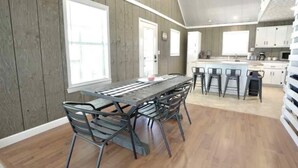 A modern kitchen with wooden walls, a central island, and bar stools. - Sugarwood Boathouse (Ten Mile)