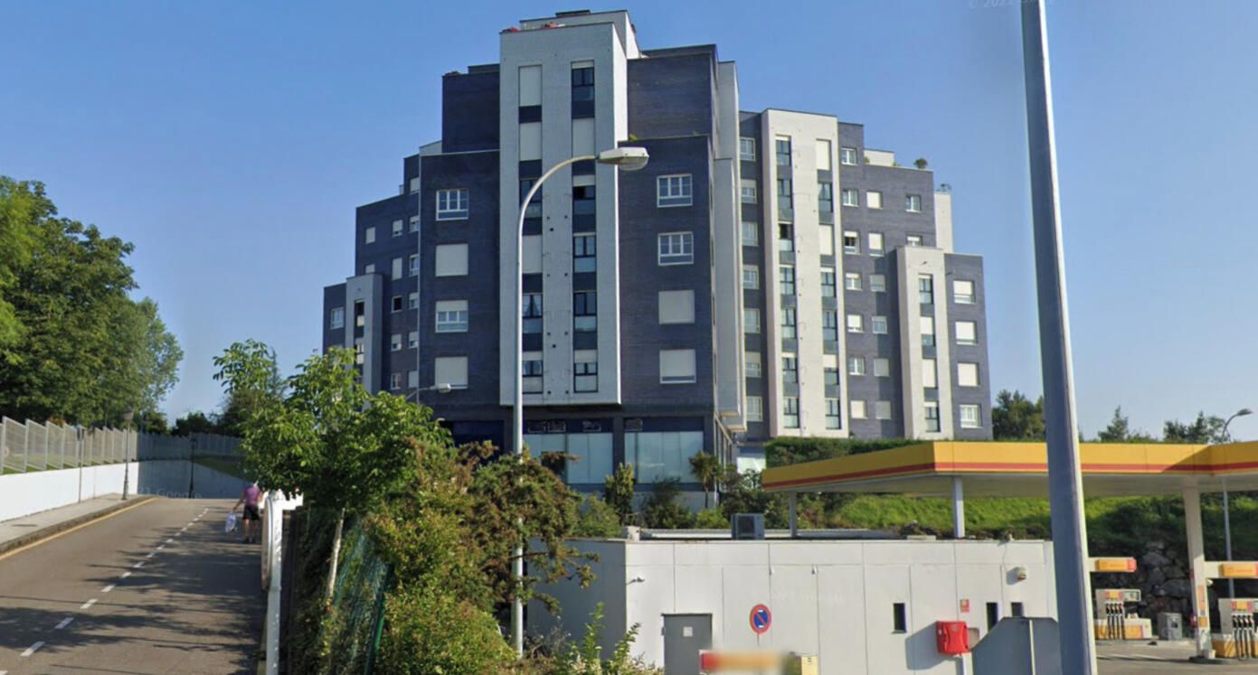 Un edificio a più piani con un design architettonico moderno, caratterizzato da un mix di finestre rettangolari e quadrate e un tetto piatto.