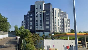 Un edificio a più piani con un design architettonico moderno, caratterizzato da un mix di finestre rettangolari e quadrate e un tetto piatto.